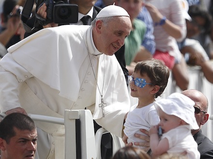 Pope greets boy as he arrives to lead general audience at Vatican