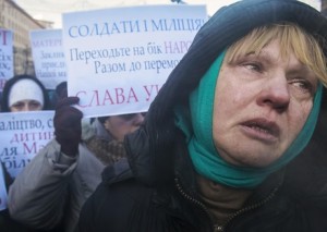 Woman cries as she and others appeal to Ukrainian police troops at site of clashes with protesters in Kiev