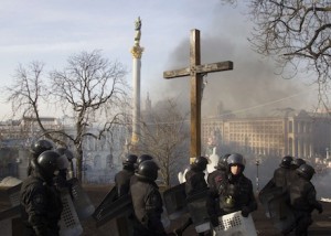 Riot police stand near crucifix during violent protest in Ukraine