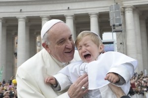 Pope Francis holds child as he arrives to lead general audience in St. Peter's Square